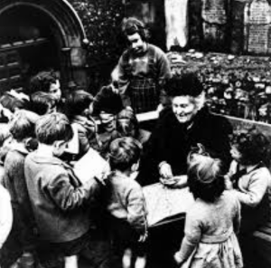 Maria MOntessori with a group of children www.womenwordswisdom.com